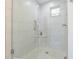 Walk-in shower features marble-patterned wall tiles, mosaic floor, and a frameless glass door at 2114 S Venus St, Tampa, FL 33629