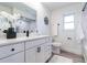 Bright bathroom with a white vanity, modern fixtures, a decorative mirror, and a walk-in shower at 2161 Aqui Esta Dr, Punta Gorda, FL 33950
