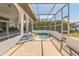 Enclosed patio with a hot tub, brick flooring, and views of the surrounding trees at 2161 Aqui Esta Dr, Punta Gorda, FL 33950