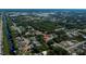 Real estate aerial view of a home in a wooded neighborhood with a canal nearby and commercial area in the distance at 2167 Corfell St, Port Charlotte, FL 33948