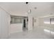 Open living room with marble floors, modern light fixture, and kitchen with a bar at 2167 Corfell St, Port Charlotte, FL 33948