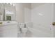 Bright bathroom featuring a tiled tub and shower, a toilet, and a vanity with bright lights at 2306 Lake Woodberry Cir, Brandon, FL 33511