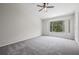 Spacious bedroom with a ceiling fan, large window, and a neutral color scheme at 2306 Lake Woodberry Cir, Brandon, FL 33511