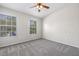A spacious, sun-filled bedroom with plush carpeting and large windows on two walls at 2306 Lake Woodberry Cir, Brandon, FL 33511