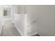 Carpeted hallway with staircase and view into a well lit room through the doorway at 2306 Lake Woodberry Cir, Brandon, FL 33511