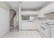 Kitchen with white cabinets, tiled flooring, and a view of the staircase and living area at 2306 Lake Woodberry Cir, Brandon, FL 33511