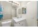 Bathroom featuring a large mirror over a white vanity with a sink, and a toilet nearby at 2373 Hounds Trl, Palm Harbor, FL 34683