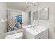 Bathroom showcasing a mirror, white vanity and sink, and a shower with a turtle-themed curtain at 2373 Hounds Trl, Palm Harbor, FL 34683