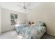 Bright bedroom with two twin beds, a ceiling fan, and a window with a view of the outdoors at 2373 Hounds Trl, Palm Harbor, FL 34683