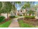 Exterior showcases townhomes with sidewalks, manicured greenery, and mature trees at 2373 Hounds Trl, Palm Harbor, FL 34683