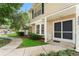 Close exterior view of a townhome, with manicured greenery and a sidewalk at 2373 Hounds Trl, Palm Harbor, FL 34683