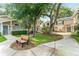 Charming exterior view of tan townhomes with mature trees, lush landscaping, and inviting walkways at 2373 Hounds Trl, Palm Harbor, FL 34683