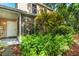 Inviting exterior view with a screened porch and lush, mature landscaping surrounding the home at 2373 Hounds Trl, Palm Harbor, FL 34683