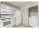 Bright kitchen features all-white cabinets, appliances, and a convenient in-closet washer/dryer at 2373 Hounds Trl, Palm Harbor, FL 34683