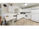 Functional kitchen featuring white cabinets, appliances, and breakfast bar at 2373 Hounds Trl, Palm Harbor, FL 34683