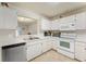 Clean kitchen with stainless dishwasher, bright countertop space and white cabinetry at 2373 Hounds Trl, Palm Harbor, FL 34683