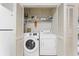 Laundry closet with modern front load Samsung washer and dryer behind white louvered doors at 2373 Hounds Trl, Palm Harbor, FL 34683