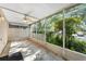 Screened-in porch with tile flooring, ceiling fan, and views of lush greenery at 2373 Hounds Trl, Palm Harbor, FL 34683
