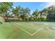 Well-maintained outdoor tennis courts surrounded by mature trees and fencing at 2373 Hounds Trl, Palm Harbor, FL 34683