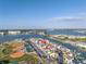 An aerial view of waterfront townhomes, showing their proximity to the bay and local baseball and tennis facilities at 250 Medallion Blvd # H, Madeira Beach, FL 33708