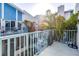 Balcony with patio seating, blue railings, and tropical landscaping at 250 Medallion Blvd # H, Madeira Beach, FL 33708
