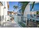 Balcony with patio furniture and blue railings overlooking palm trees and nearby buildings at 250 Medallion Blvd # H, Madeira Beach, FL 33708