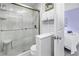Tiled bathroom features glass enclosed shower, toilet, and towel rack with nautical artwork and adjacent bedroom at 250 Medallion Blvd # H, Madeira Beach, FL 33708