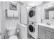 Bathroom features a modern stacked washer and dryer, vanity, toilet, and decorative nautical-themed artwork at 250 Medallion Blvd # H, Madeira Beach, FL 33708