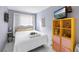 Bedroom features a comfortable bed, TV with bright yellow shelf, and window at 250 Medallion Blvd # H, Madeira Beach, FL 33708