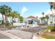 Community entrance with a guard house and tropical landscaping on a sunny day at 250 Medallion Blvd # H, Madeira Beach, FL 33708
