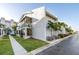 View of condo building exterior with screened in lanai and landscaping at 250 Medallion Blvd # H, Madeira Beach, FL 33708