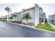 Beautiful condo building exterior featuring palm trees and green grass at 250 Medallion Blvd # H, Madeira Beach, FL 33708