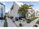 Community patio with BBQ grill and tables surrounded by lush tropical landscaping at 250 Medallion Blvd # H, Madeira Beach, FL 33708