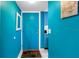 Hallway with a bright blue entry door, tile floor, and fun beachy decor at 250 Medallion Blvd # H, Madeira Beach, FL 33708
