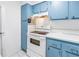Kitchen showcasing a white oven, blue cabinets, and ample storage space at 250 Medallion Blvd # H, Madeira Beach, FL 33708