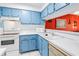 Bright kitchen featuring blue cabinets, white countertops, and essential appliances at 250 Medallion Blvd # H, Madeira Beach, FL 33708