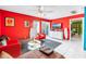 Cozy living room with vibrant walls, white tile floors, and a sliding door to the balcony at 250 Medallion Blvd # H, Madeira Beach, FL 33708