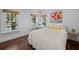 Sunny bedroom with hardwood floors, bright windows, and a comfortable white bed at 2523 W Sunset Dr, Tampa, FL 33629