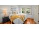 Bright bedroom featuring wood floors, fresh paint, bedside table, and a decorative throw blanket at 2523 W Sunset Dr, Tampa, FL 33629