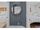 Hallway featuring a round mirror on a blue wall leading to bedrooms with white bedding at 2523 W Sunset Dr, Tampa, FL 33629