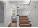 Hallway showcasing a carpeted staircase, hardwood floors, and views into the living room and bathroom at 2523 W Sunset Dr, Tampa, FL 33629