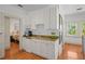 Cozy kitchenette with white cabinets, granite countertops, and a view into the bedroom at 2523 W Sunset Dr, Tampa, FL 33629