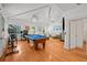 Spacious living room with a pool table, vaulted ceilings, and hardwood floors at 2523 W Sunset Dr, Tampa, FL 33629