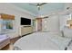 Bright main bedroom with tray ceiling, large window, and a decorative sliding barn door to the bathroom at 2523 W Sunset Dr, Tampa, FL 33629