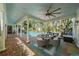Covered outdoor patio with a dining area, ceiling fan, and pool in the background at 2523 W Sunset Dr, Tampa, FL 33629