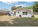 Backyard view of the rear of the house with partial fence, AC unit, and lawn at 2604 Oakdale St, Seffner, FL 33584