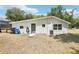 Backyard view of the rear of the house with back door, AC unit, and grass yard at 2604 Oakdale St, Seffner, FL 33584