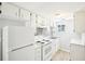 Clean kitchen with white cabinets and appliances, featuring a modern backsplash at 2604 Oakdale St, Seffner, FL 33584