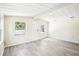 Bright living room with wood-look tile flooring, white ceiling and trim, and views of the front yard at 2604 Oakdale St, Seffner, FL 33584