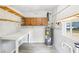 Storage area features light tile flooring, work table, water heater, shelving, and window at 2604 Oakdale St, Seffner, FL 33584